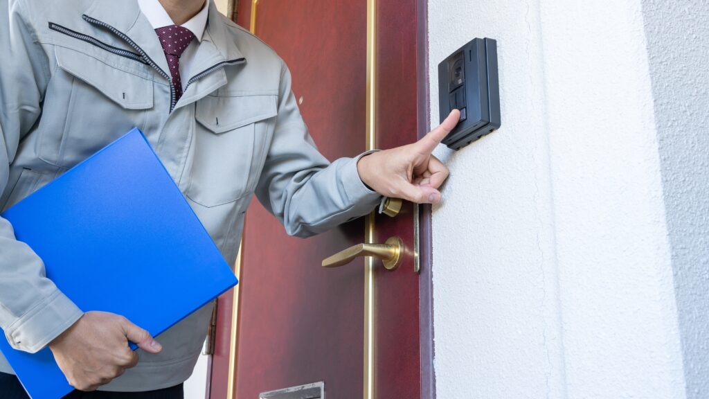 A salesman pressing a doorbell in door-to-door sales.